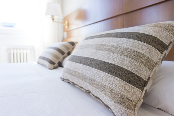 bedroom bedding pillows wooden headboard lamp